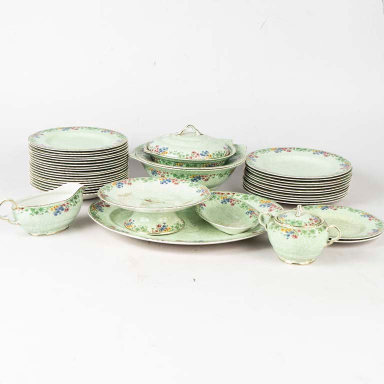 38 Piezas de loza inglesa Fairfield. Diseño flores, fondo verde, borde lobulado dorado. Piezas manchadas, 3 platos con cascaduras y 3 platos con fisuras. Medidas: 20 cm