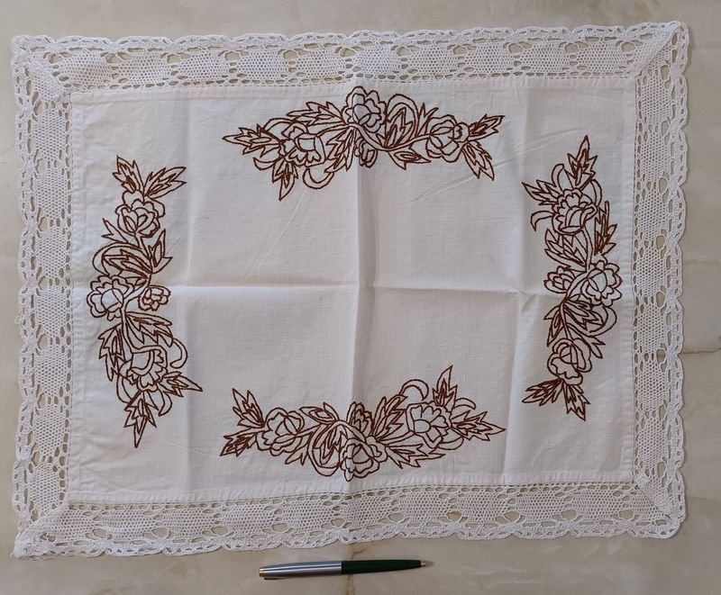 Mantelito con bordado floral marrón y bordes en crochet