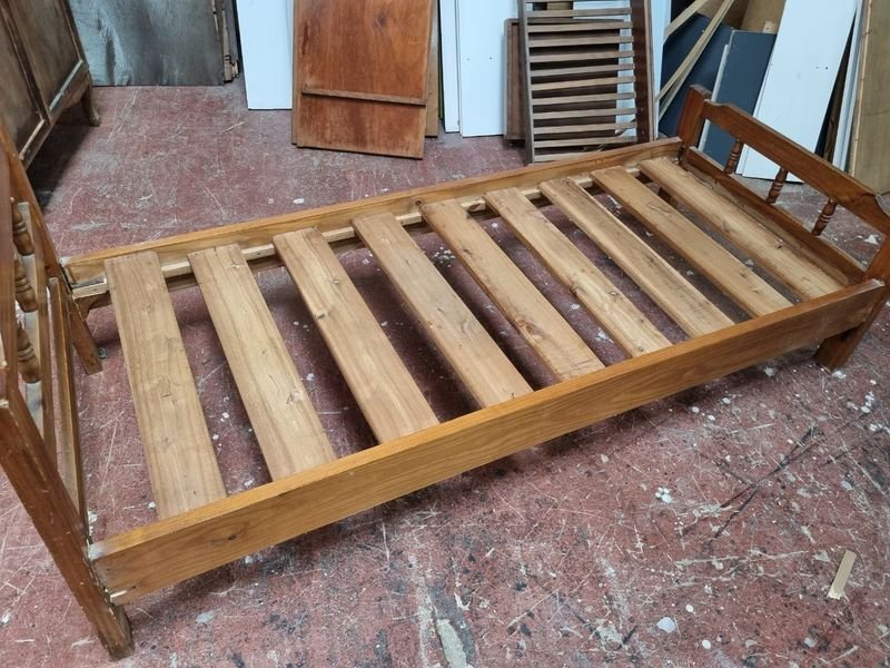 Cama de madera con diseño de tablas y cabeza de tornillo