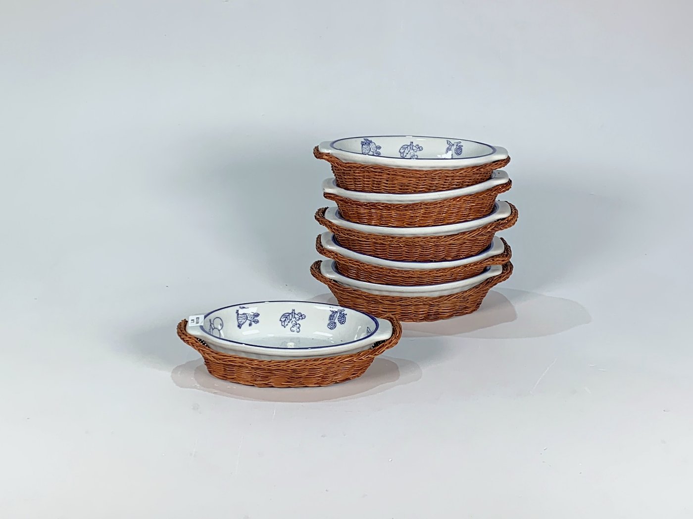 Seis Cazuelas Ovales de Losa Blanca con Soporte de Ratán y Decoración de Frutos Azules