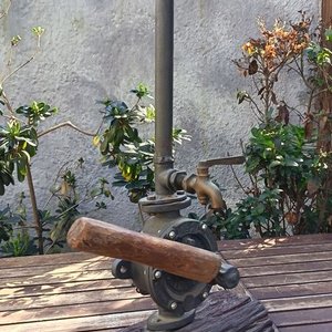 Lámpara de mesa artesanal de estilo rústico La base está compuesta por un robusto medio tronco de madera noble con su corteza natural texturizada, sobre el cual se monta el cuerpo principal de una antigua bomba de agua manual giratorio de hierro fundido No. 2 Allwilen Original Pumpe. Incorpora detalles de fontanería vintage como cañerías de hierro y una canilla de bronce decorativo en el eje. En Muy bueno estado de Conservación. Medidas Sin pantalla: Alto 72 cm - Base Largo 33 cm - imagen 4