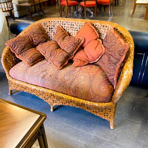 Lote siguiente: Sofá de mimbre con almohadones estampados