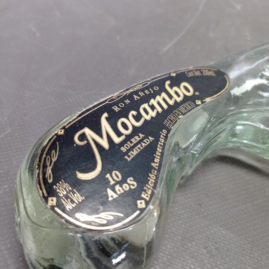 Botella de ron con forma de pistola y etiqueta con diseño ornamental - imagen 3