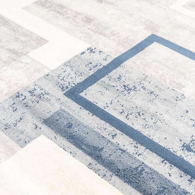 Alfombra acrílica con diseños geométricos en colores celeste, azul, gris y blanco - imagen 2