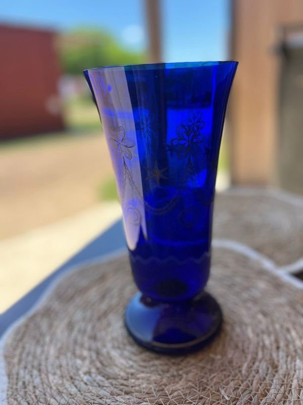 Lote siguiente: Florero decorativo de vidrio azul con diseño floral
