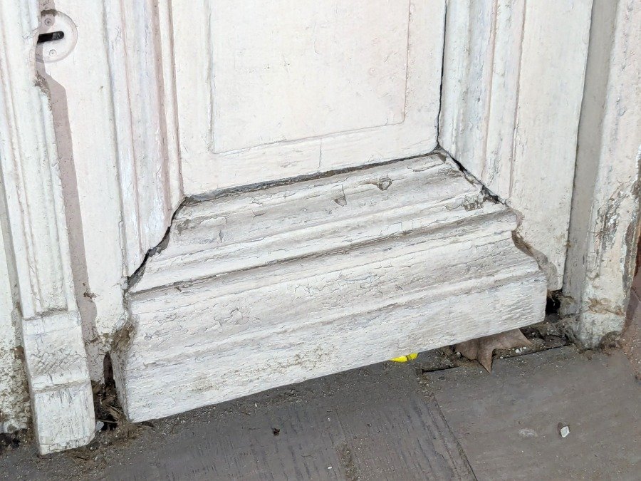 Puerta de dos hojas batientes en cedro con diseño de tablero y manotones de bronce - imagen 5