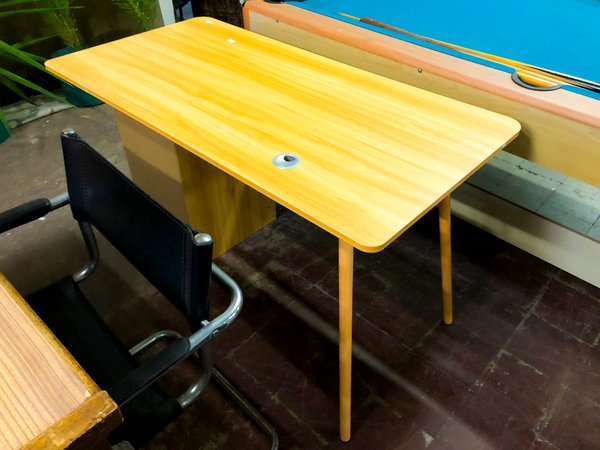 Mesa de madera clara con patas cónicas