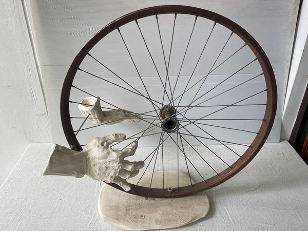 Obra de Arte: Rueda de Bicicleta con Manos Esculpidas
