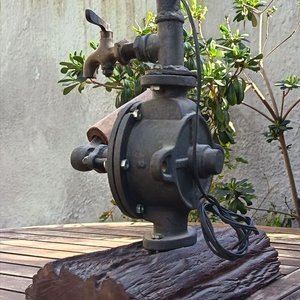 Lámpara de mesa artesanal de estilo rústico La base está compuesta por un robusto medio tronco de madera noble con su corteza natural texturizada, sobre el cual se monta el cuerpo principal de una antigua bomba de agua manual giratorio de hierro fundido No. 2 Allwilen Original Pumpe. Incorpora detalles de fontanería vintage como cañerías de hierro y una canilla de bronce decorativo en el eje. En Muy bueno estado de Conservación. Medidas Sin pantalla: Alto 72 cm - Base Largo 33 cm - imagen 3