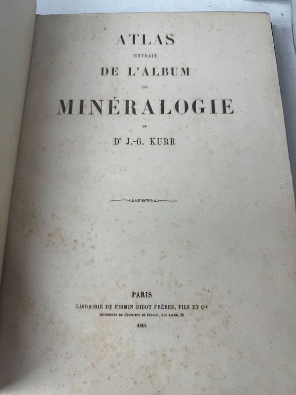 Libro antiguo de mineralogía con una mano en la cubierta - imagen 2