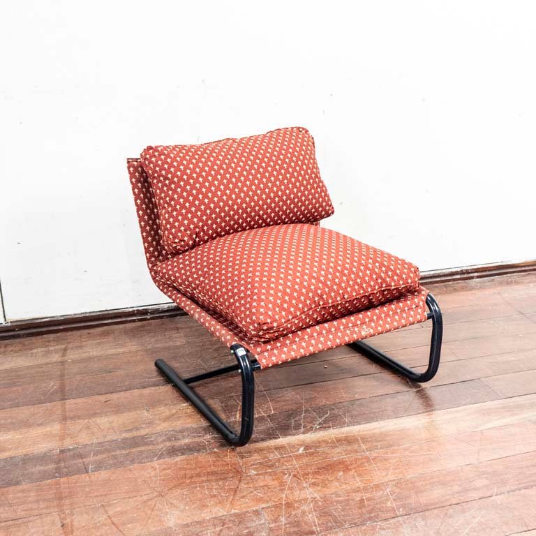 Lote siguiente: Sillón bajo de diseño moderno con estructura metálica y asiento tapizado