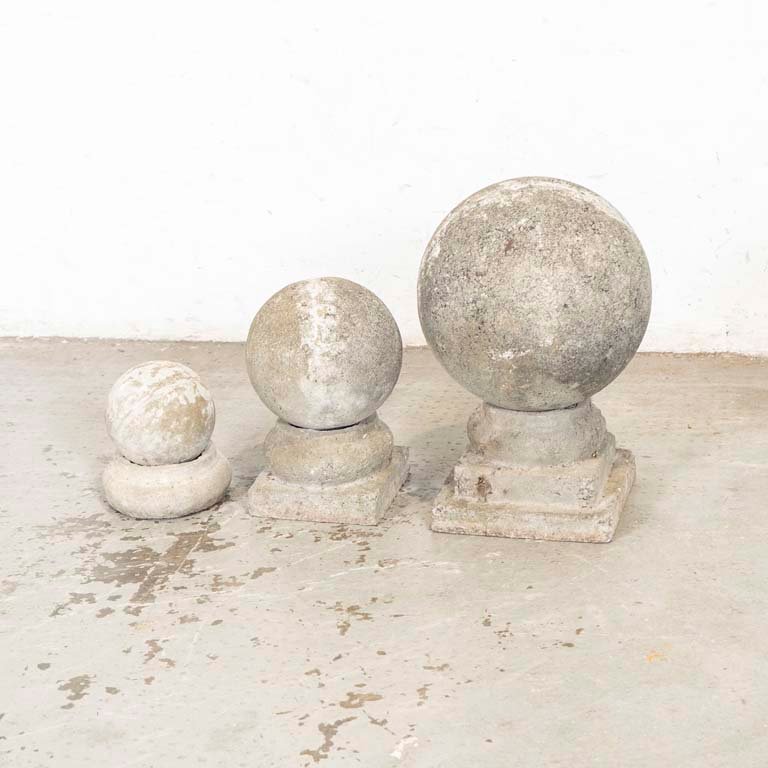 Tres bolas de piedra o cemento de diferentes tamaños