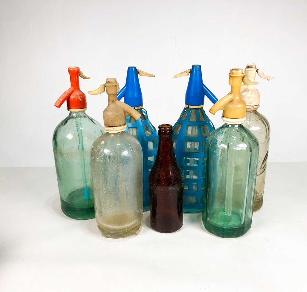 Lote siguiente: Colección de botellas de vidrio con diferentes colores y formas