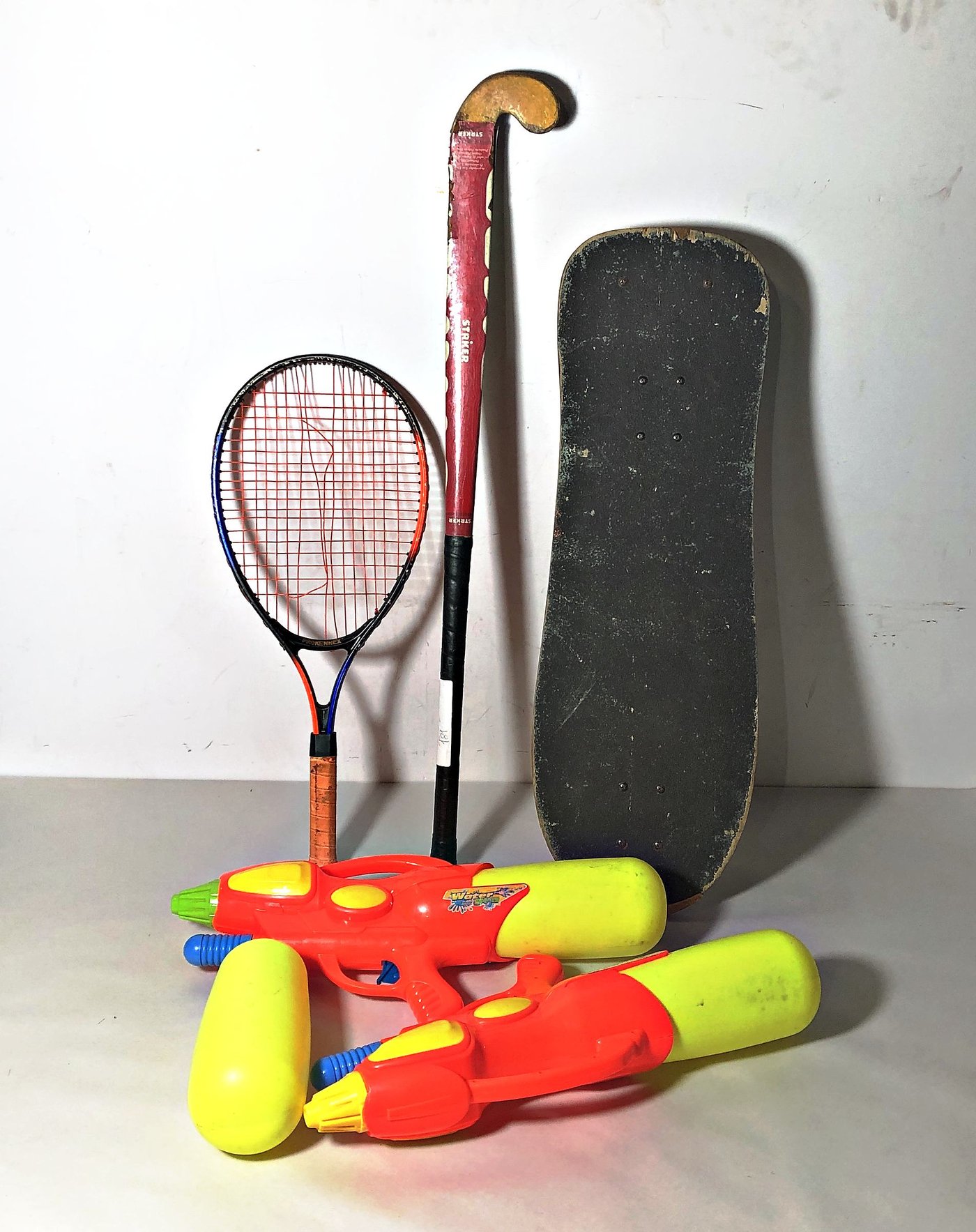 Lote de 5 piezas: Patineta, Palo de Hockey, Raqueta y 2 Pistolas de Agua