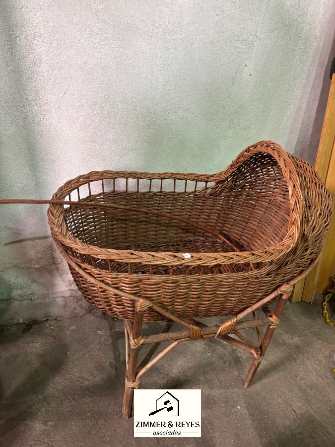 Cuna de mimbre antigua con base de madera
