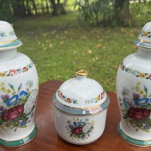 1 juego en porcelana española V.P compuesto por 2 jarrones tipo potiche y 1 alajero con tapa. Su diseño es fino y elegante con montivos florales y guardas al rededor de las piezas montadas sobre un platillo (24 y 13 las medidas) - imagen 4