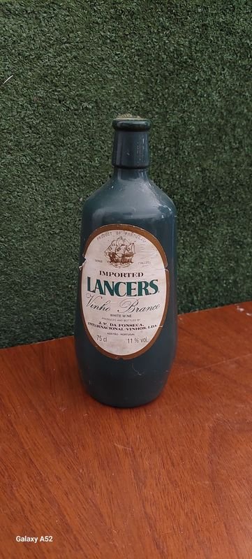 Lote siguiente: Botella de vino con etiqueta blanca y azul