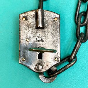 Antiguo candado de estancia con cadena integrada. Con llave. Funcionando. Sellado con el logo de un perro ovejero apoyado en un candado. - imagen 3