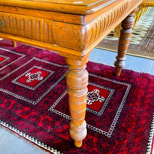 Mesa de madera antigua con cajones y alfombra persa roja - imagen 2