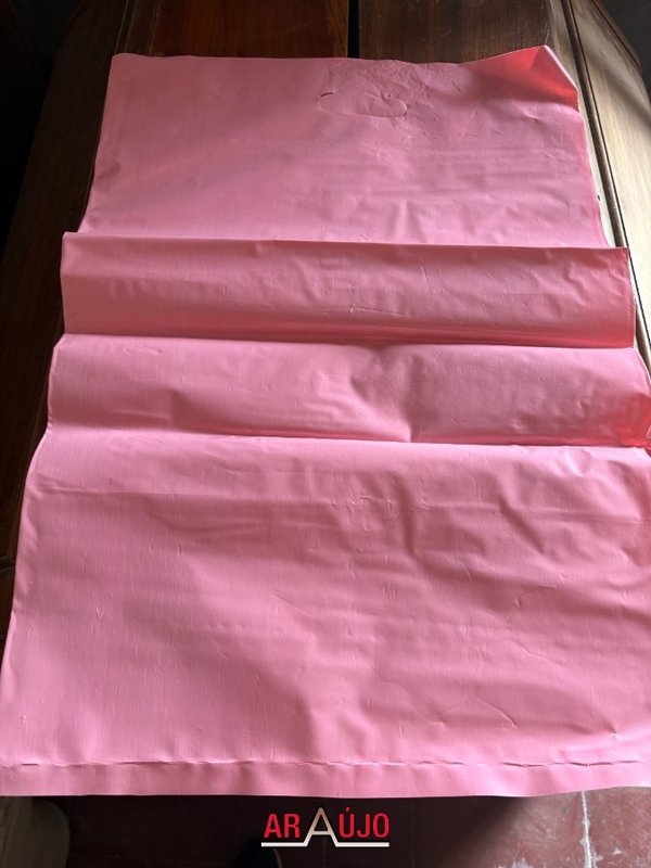 Valija de cuero marrón con bolsas de plástico rosas y amarillas