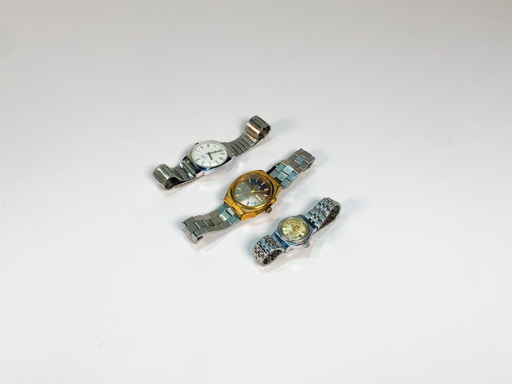 Tres Relojes de Pulsera para Dama y Caballero: Dorado con Calendario, Esfera Blanca y Números Romanos, y Esfera Plateada con Números Dorados