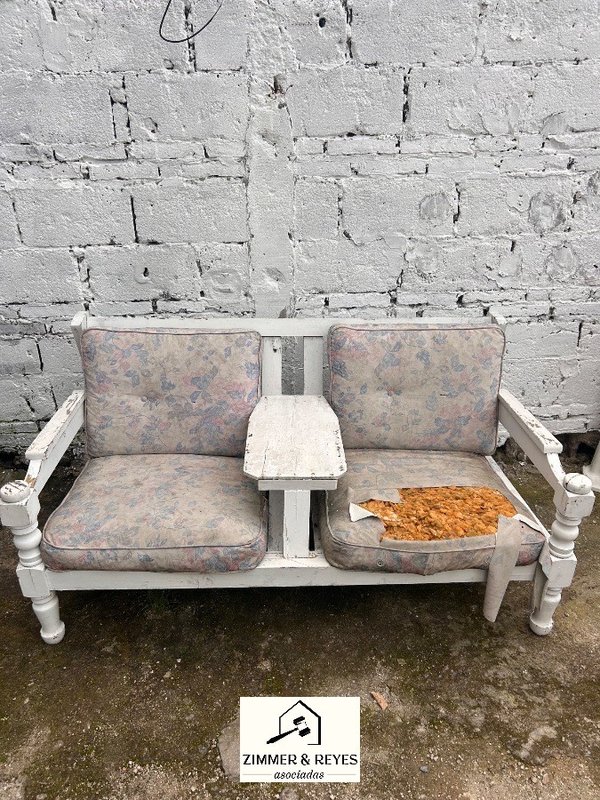 Sillón de patio doble con almohadones y mesa central