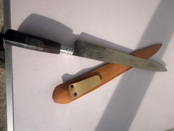 Cuchillo de Hoja Metálica con Mango Oscuro y Vaina de Cuero