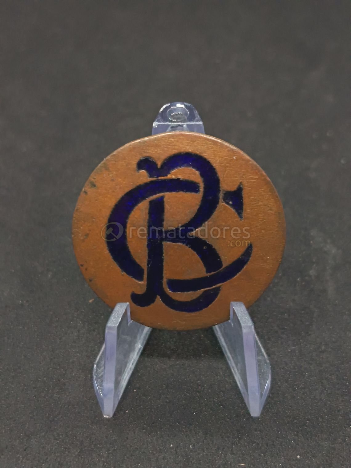 Medalla o Pin Metálico con Logo "R.C." y Número "64"
