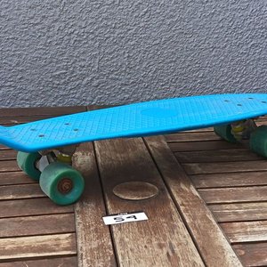 Skate tipo cruiser de plástico color celeste, con cuatro ruedas y ejes metálicos; usado. - imagen 1