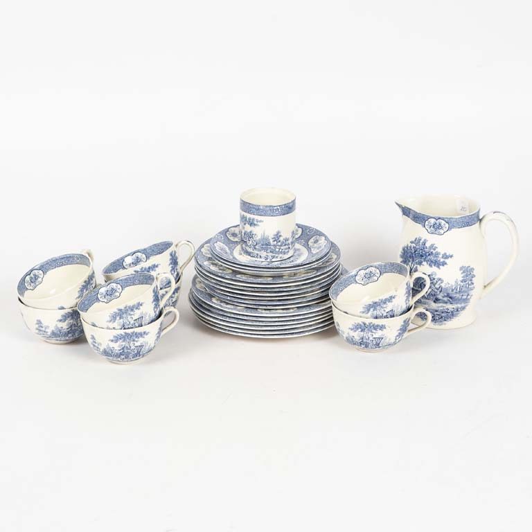 Lote siguiente: 25 Piezas de juego de té de loza inglesa Adams Blue Laurnton. Fondo blanco con escena campestre. Taza de té con fisura y una con el asa restaurada, lechera con mínima cascadura, plato de lunch con cascadura - Medidas: Taza de té 10x6cm