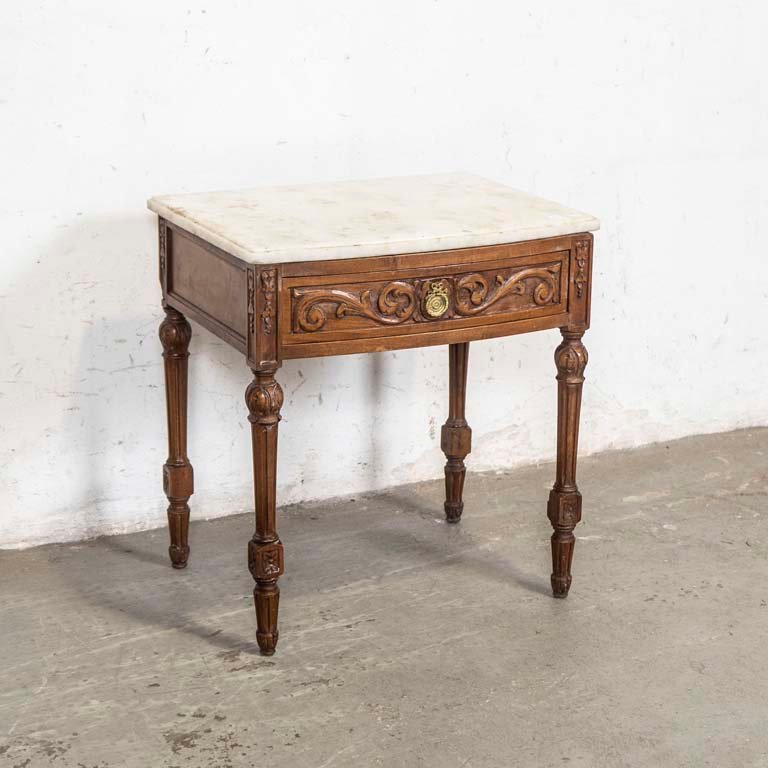 Lote siguiente: Mesa de luz Luis XVI tallada con tapa de mármol y cajón