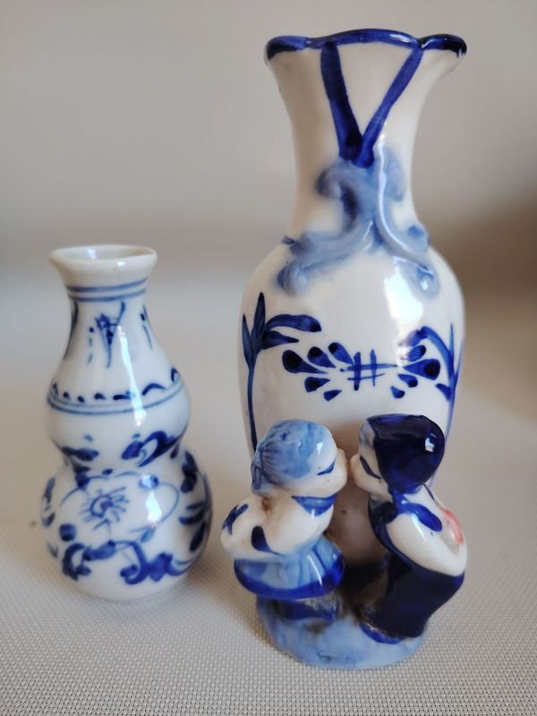 Dos floreros de porcelana azul y blanca con diseño besándose - imagen 1