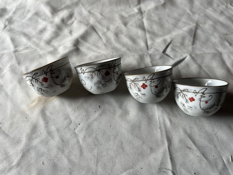 Lote siguiente: Porcelana blanca con flores rojas en cuatro tazas