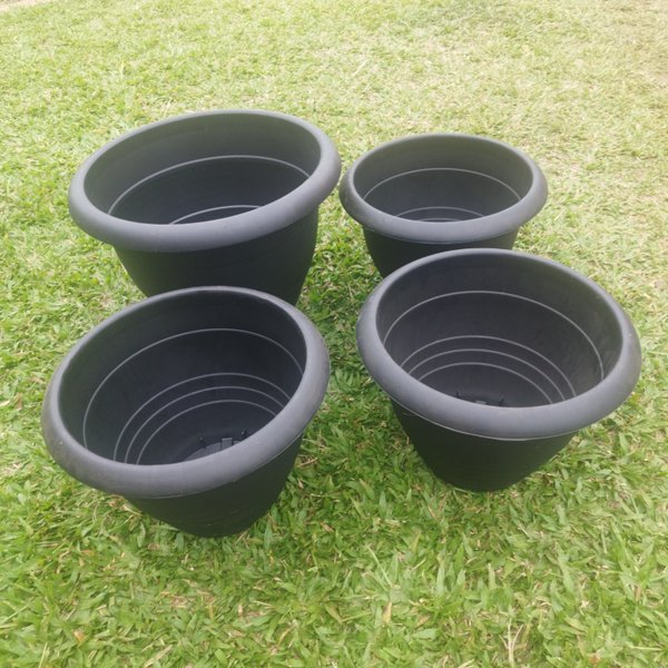 Cuatro macetas plásticas negras de PVC