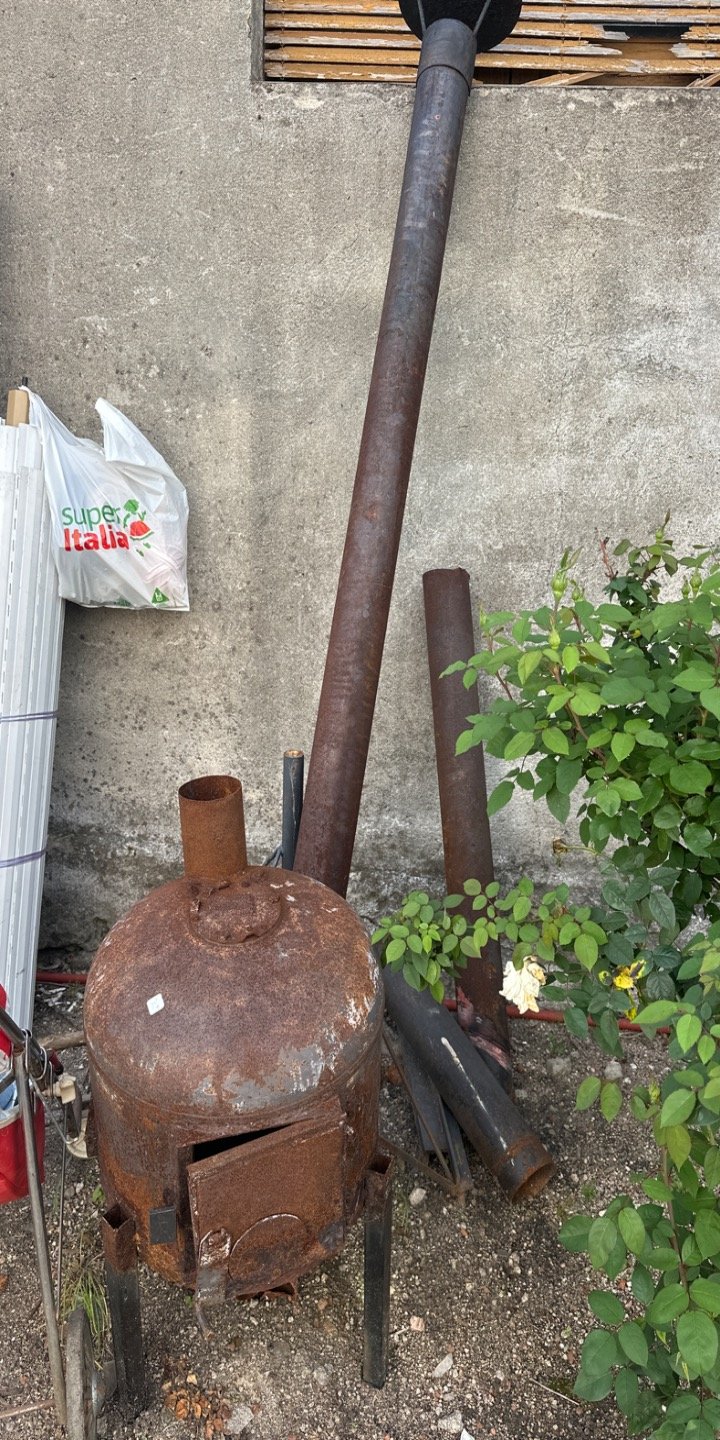Estufa a leña antigua con caños de metal