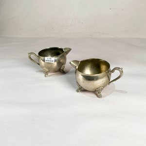 Lote siguiente: Dos Cremosas Metálicas con Pie y Asa Labrados