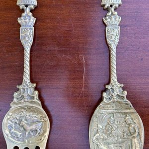 Lote siguiente: 1 par de utensillos decorativos en bronce macizo de gran tamaño y peso conmemorativos de holanda (tenedor vaca con granjero evocando la vida rural y la agricultura, con un molino en su otro extremo y un escudo heraldico, cuchara evoca una escena en un meson o taberna lugares tipicos de las zonas rurales en los siglos 16 y 17)