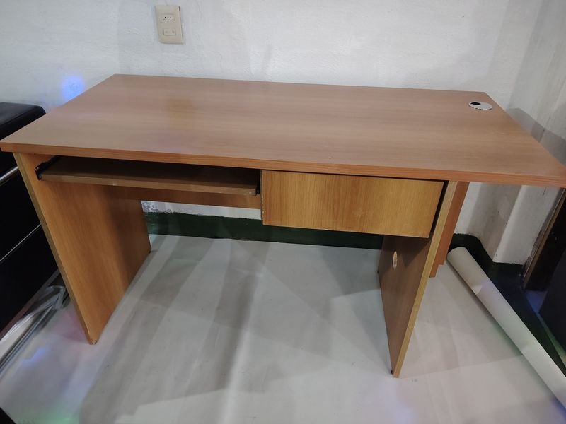 Escritorio de madera con espacio para teclado, cajón y torre
