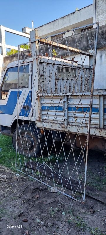 Lote siguiente: Reja de metal con camión viejo