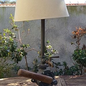 Lote anterior: Lámpara de mesa artesanal de estilo rústico La base está compuesta por un robusto medio tronco de madera noble con su corteza natural texturizada, sobre el cual se monta el cuerpo principal de una antigua bomba de agua manual giratorio de hierro fundido No. 2 Allwilen Original Pumpe. Incorpora detalles de fontanería vintage como cañerías de hierro y una canilla de bronce decorativo en el eje. En Muy bueno estado de Conservación. Medidas Sin pantalla: Alto 72 cm - Base Largo 33 cm
