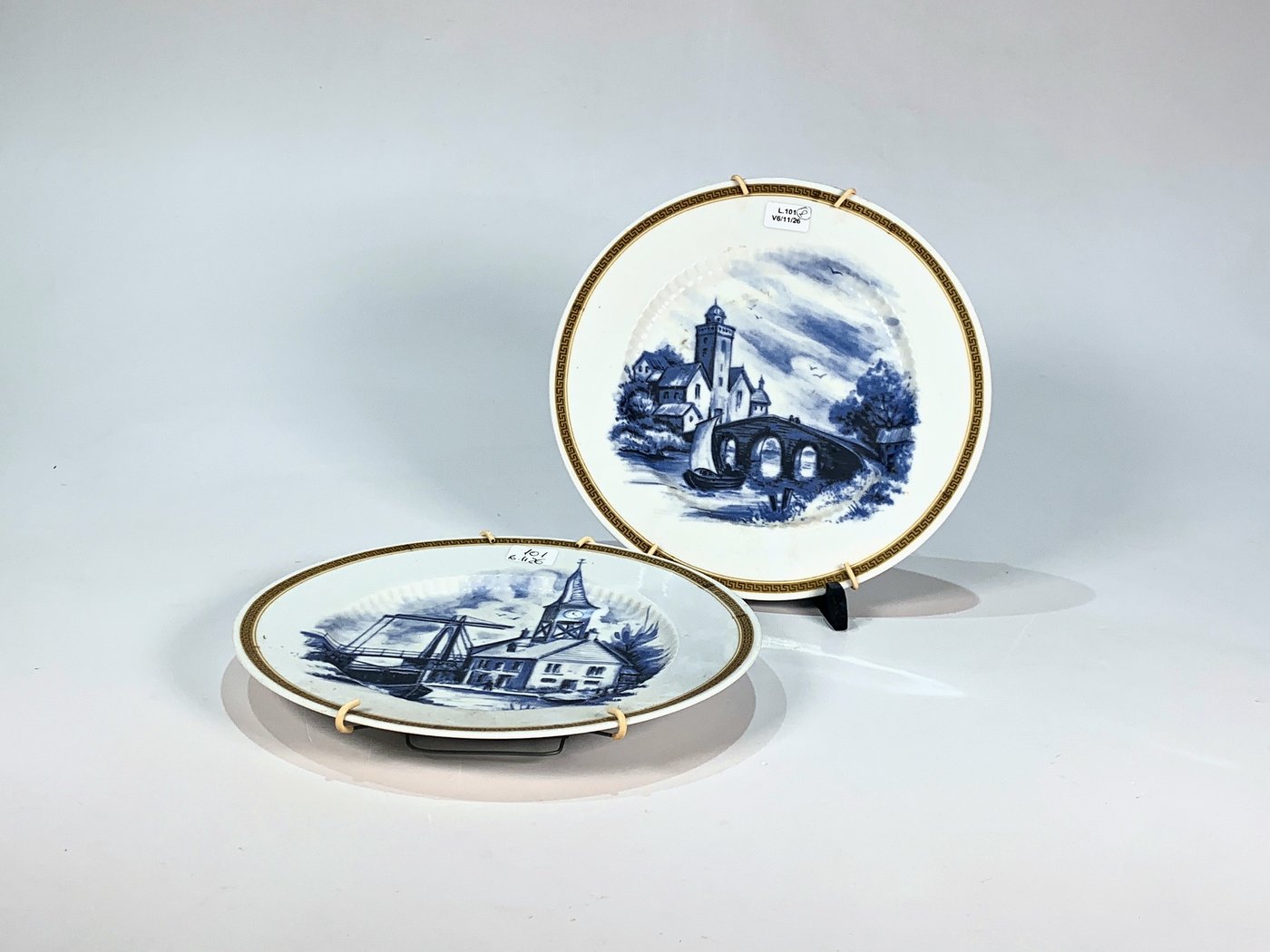 Dos Platos Llanos de Porcelana Blanca con Decoración de Caseríos y Barcas en Azul y Guarda Dorada Griega