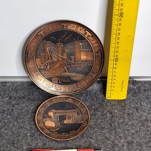 Lote siguiente: Dos Platos Decorativos de Metal Cobreado con Motivos de Chile