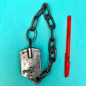 Lote anterior: Antiguo candado de estancia con cadena integrada. Con llave. Funcionando. Sellado con el logo de un perro ovejero apoyado en un candado.