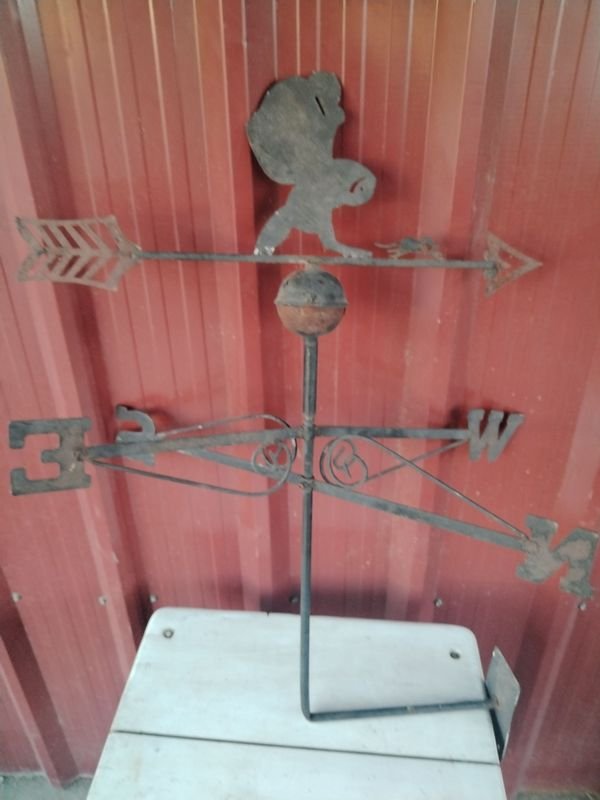 Reloj antiguo con gato en una pared roja