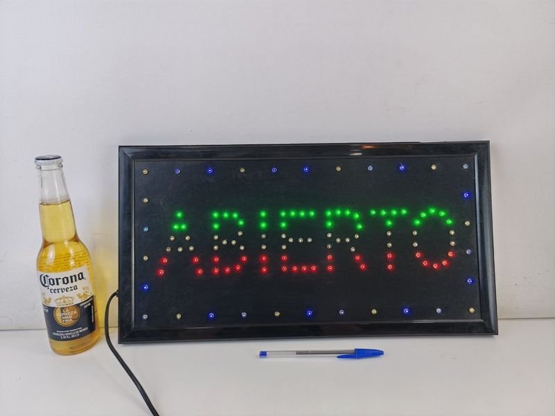 Lote siguiente: Cartel de Abierto: Un signo luminoso y una botella de Corona