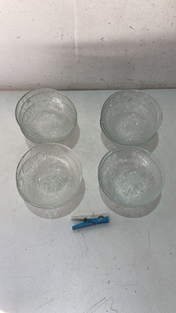 Lote siguiente: Cuatro tazas de vidrio y un objeto plástico azul