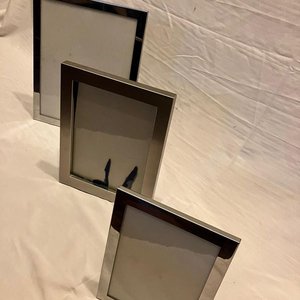 Lote siguiente: Lote de tres portarretratos individuales de metal con acabado plateado.