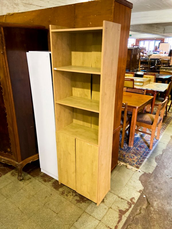Estantería de madera clara con puertas inferiores