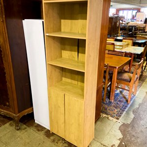 Lote anterior: Estantería de madera clara con puertas inferiores