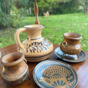Lote siguiente: 7 adornos varios (cantaro en gade decorado a mano, dos calderos artesanales en madera rustica, platos con diseño de animales en cobre, escultura en madera de un ave y espejo)